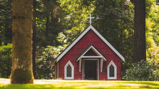 Red Chapel on Grassy Field With Trees