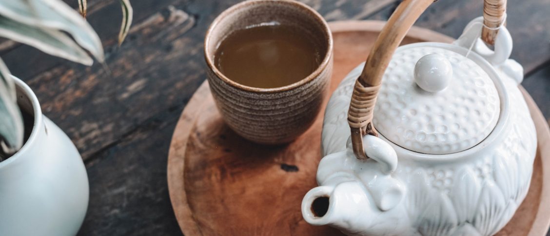 white and brown ceramic teapot on wooden tray