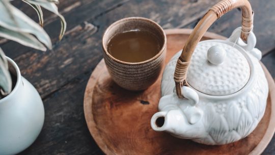 white and brown ceramic teapot on wooden tray