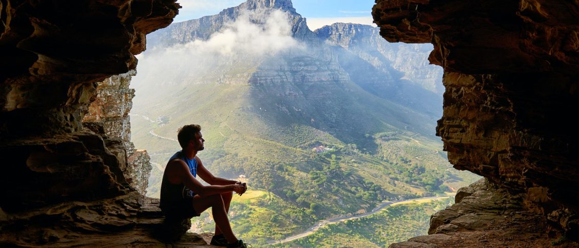 Photo of Man Sitting on a Cave