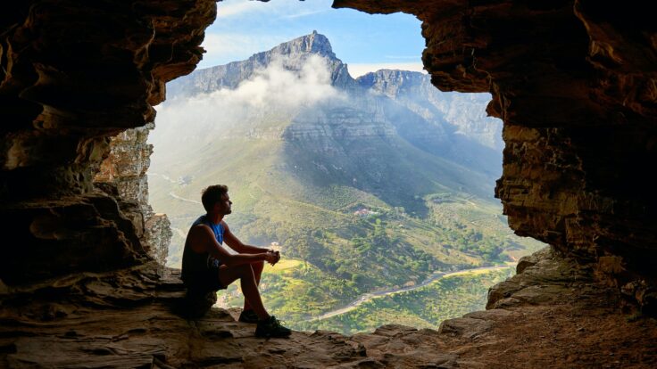 Photo of Man Sitting on a Cave