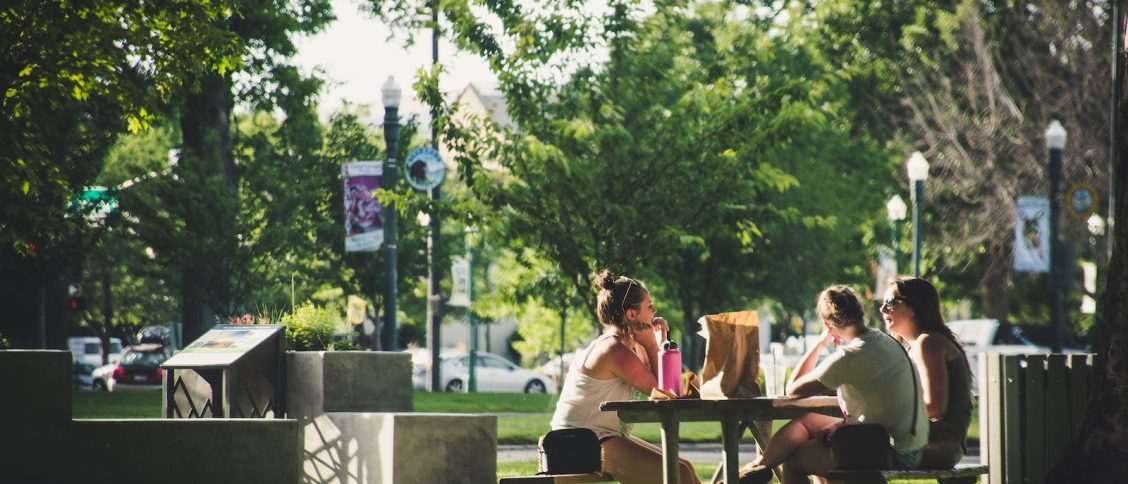 Three Women Sitting On Benches