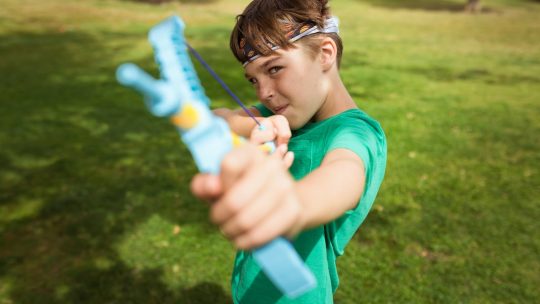 Close-Up Shot of a Boy Using a Slingshot