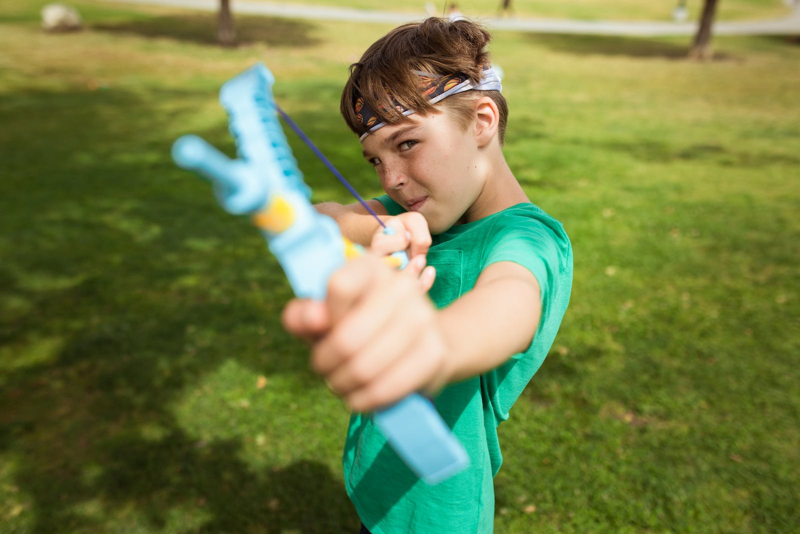 Close-Up Shot of a Boy Using a Slingshot