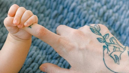 Person With Black and Blue Tattoo on Right Hand