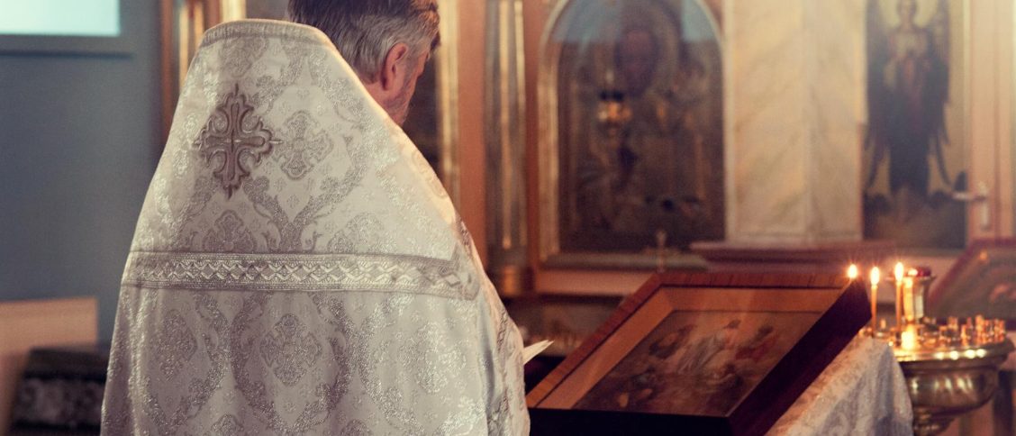 Father Standing in Front of Alter