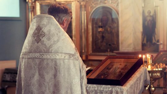 Father Standing in Front of Alter